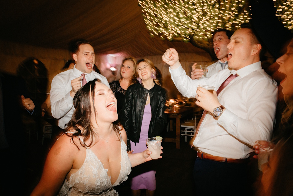 bride and guests dancing at wedding reception