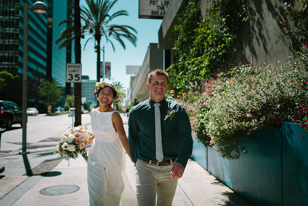 happy newlyweds walking down sidewalk